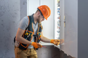 Électricien professionnel travaillant sur un tableau électrique - EC Pays d'Auge Rénovation lance son nouveau site web